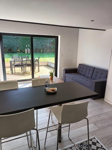 un salon avec une table, des chaises et un canapé dans l'établissement Appartement 30 m2 neuf + terrasse, à Brindas