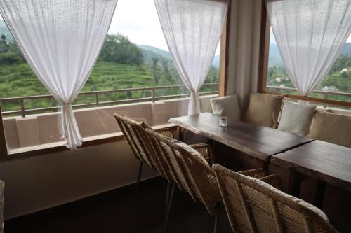 a dining room with a table and chairs and a window at Earthy room - THHPSOCIETY - THE HUMAN HAPPINESS PROJECT in Mukteswar