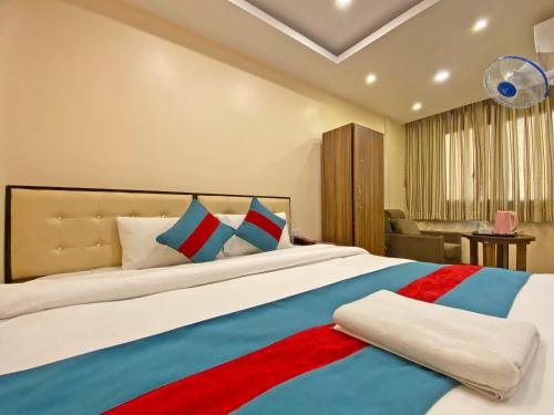 a bedroom with a large bed with blue and red pillows at Hotel Airport Holiday in Kathmandu