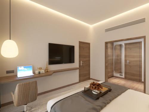 a bedroom with a bed and a tv on a wall at Kertel Suites Kinshasa in Kinshasa