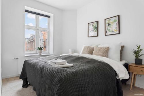 a bedroom with a bed with two towels on it at Premium High-Street Home w Large Private Terrace in Aarhus