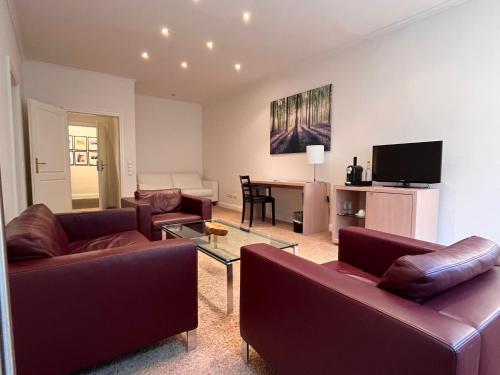 a living room with couches and a table with a television at Hotel Kieler Yacht-Club in Kiel