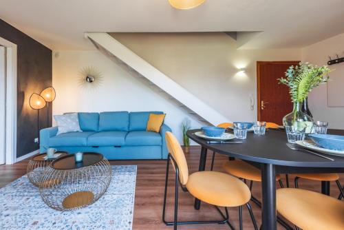 un salon avec un canapé bleu et une table dans l'établissement La Bulle de Lumière - Central et Chaleureux, à Brumath