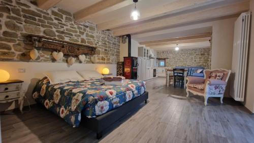 a bedroom with a bed and a stone wall at La Casetta Agriturismo in Santa Sofia