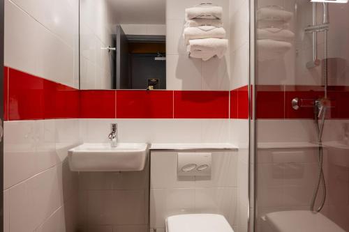 a bathroom with a toilet and a sink and a shower at Kyriad Paris 10 - Canal Saint Martin - République in Paris