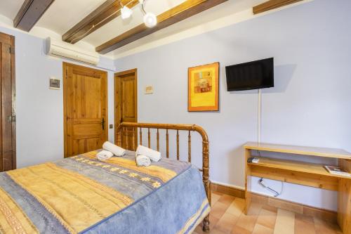 a bedroom with a bed and a flat screen tv at Casa Roca Sant Martí de Barcedana in Aransís