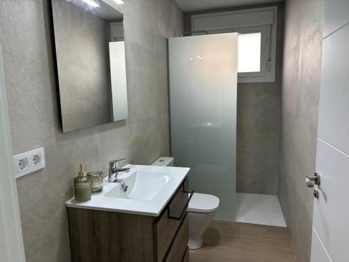 a bathroom with a sink and a toilet and a mirror at Mercedes Park in Montilla