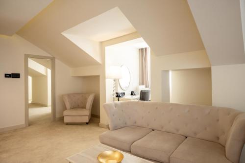 a living room with a couch and a chair at Tresor Le Palais Timisoara, Curio Collection by Hilton in Timişoara