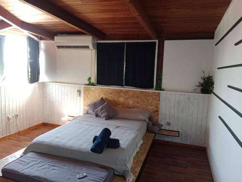 a bedroom with a bed with a blue teddy bear on it at El Escondite Perfecto in Benacazón