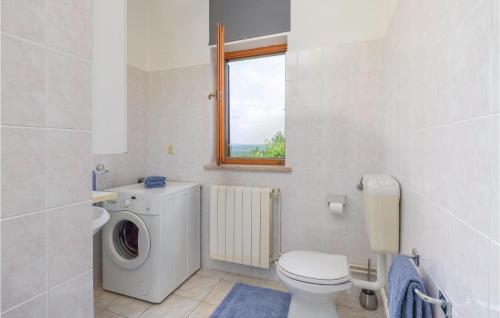 a white bathroom with a washing machine and a window at 7 Bedroom Nice Home In Labin in Labin