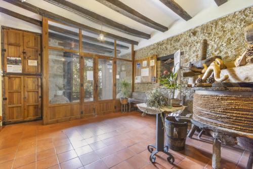 a room with a stone wall and a large glass door at Casa Roca Sant Martí de Barcedana in Aransís
