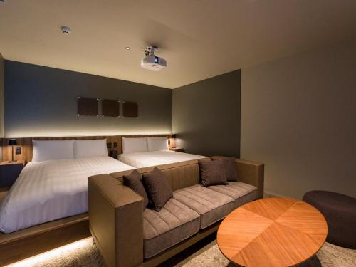 a bedroom with two beds and a couch and a table at Rakuten STAY TERRACE Hakone Kowakudani in Hakone