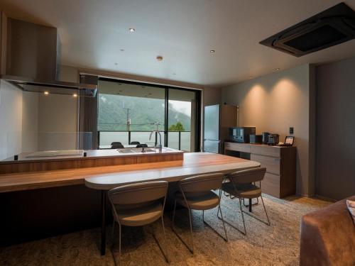 a kitchen with a large wooden table and a large window at Rakuten STAY TERRACE Hakone Kowakudani in Hakone