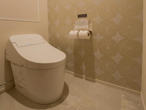 a toilet in a bathroom with a roll of toilet paper at Rakuten STAY TERRACE Hakone Kowakudani in Hakone