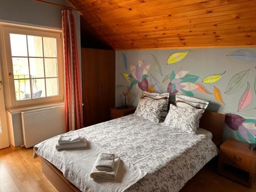 a bedroom with a large bed with a floral wall at Pensiunea Victoria in Râşnov