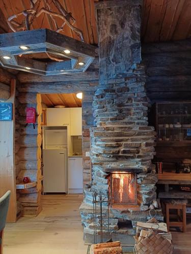 a stone fireplace in a room with a kitchen at Rukan Kelostar in Kuusamo