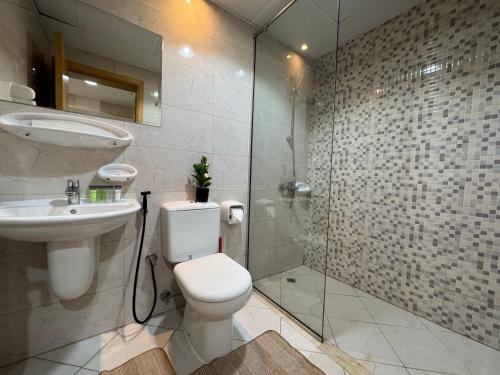 a bathroom with a toilet and a sink and a shower at ASHRI HH Spacious Studio in May Residence JVC in Dubai
