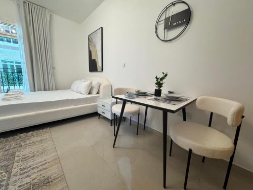 a living room with a bed and a table and chairs at ASHRI HH Spacious Studio in May Residence JVC in Dubai