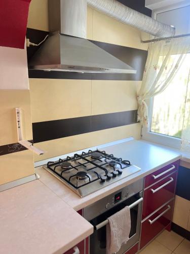a kitchen with a stove top oven next to a window at Bella space in Suceava