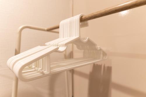 a white towel rack hanging from a shower door at 大吉屋本館 ワンフロア貸切部屋 名駅離れ in Nagoya