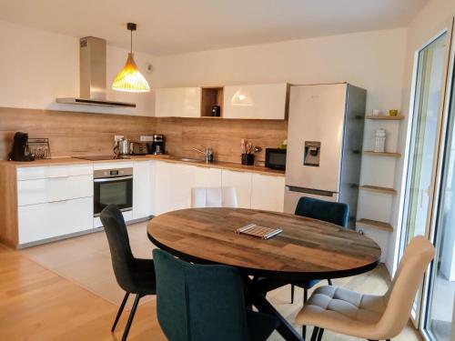 une cuisine avec une table, des chaises et un réfrigérateur dans l'établissement Blue Dock sur le Port Parking Wifi Linge en option, à Vannes