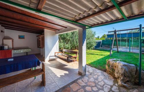 un patio con pérgola de madera y un banco en 1 Bedroom Amazing Apartment In Liznjan, en Ližnjan