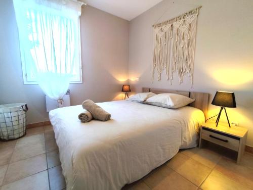 une chambre avec un grand lit blanc et une fenêtre dans l'établissement La Noria - Confort et Facilité - Parking, à Aucamville