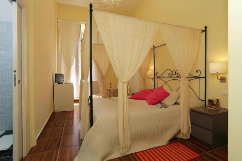 Un dormitorio con una cama con dosel y almohadas rojas. en Locanda al Viminale, en Roma