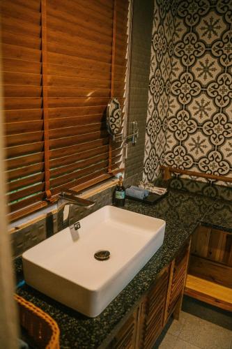 a bathroom with a white sink on a counter at Anna Little Garden - Fish House in Sóc Sơn