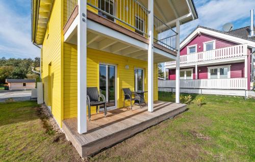 a yellow house with two chairs on a porch at Seehund Xl in Süssau