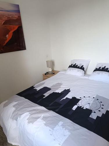 - une chambre dotée d'un lit blanc avec une photo sur le mur dans l'établissement Dans la brise du Rhône, à Arles