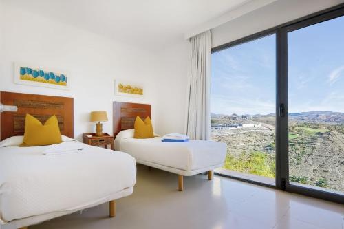 two beds in a room with a large window at Holiday Home Villa Gema in Maspalomas