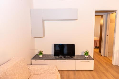 a living room with a tv and a couch at La Casa di Lella in residence con piscina in Paratico