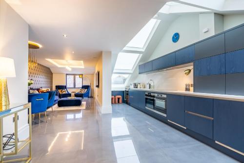 a kitchen with blue cabinets and a living room at Boutique Apartment at The Old Fire Station in York