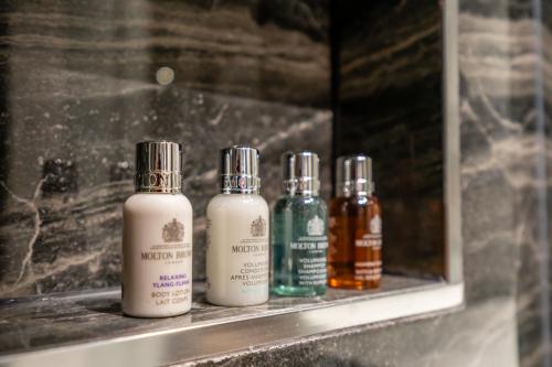 a row of four bottles sitting on a shelf at Boutique Apartment at The Old Fire Station in York
