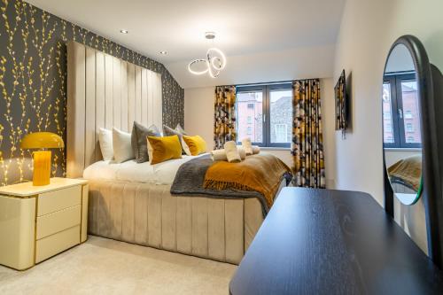 a bedroom with a large bed with yellow pillows at Boutique Apartment at The Old Fire Station in York