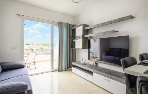 ein Wohnzimmer mit einem großen TV und einem Sofa in der Unterkunft Nice Home In Puerto Rico De Gran Ca in Puerto Rico de Gran Canaria