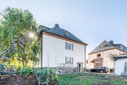 a white house with a black roof at Yvette's Ferienwohnung in Lugau
