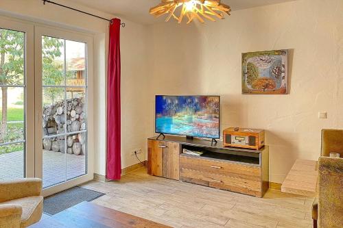 a living room with a flat screen tv and a window at Blockhaus Baum 3 in Burg