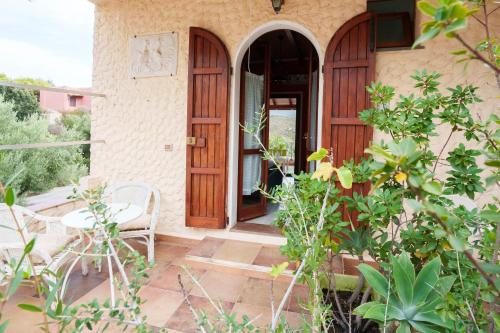 a house with a wooden door and a table and chairs at Hotel Villa Belfiori in Torre Dei Corsari