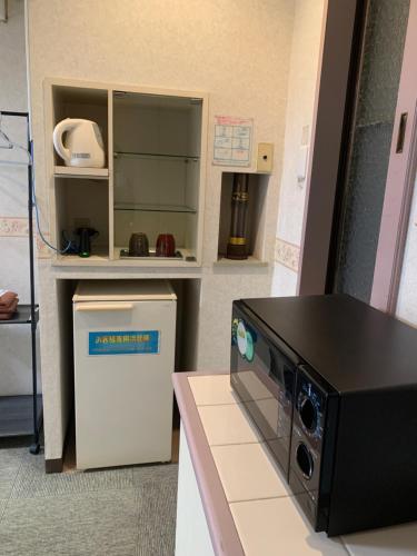 a toy kitchen with a microwave and a refrigerator at Village BFH in Omura