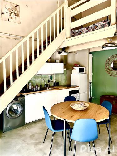 une cuisine et une salle à manger avec une table et des chaises bleues dans l'établissement Atypique et Charmant Nid Urbain, à Marseille