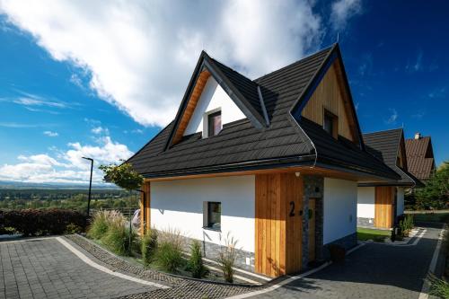 a house with a black roof at Słoneczne Chatki in Knurów
