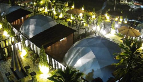 two umbrellas in a patio with lights at night at Gold Crest Cameron Highlands in Tanah Rata