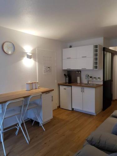 - une cuisine avec des placards blancs et un bureau dans la chambre dans l'établissement Pretty little flat near from DisneyLand Paris, à Bussy-Saint-Georges