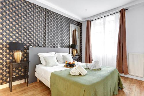 une chambre avec un lit avec deux serviettes dessus dans l'établissement Bluestay 20 - Superb apartment in Paris, à Paris