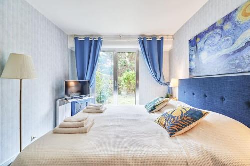 - une chambre avec un grand lit aux murs bleus et une fenêtre dans l'établissement Charming 2BR Private garden, 5MinToBeach Deauville, à Deauville