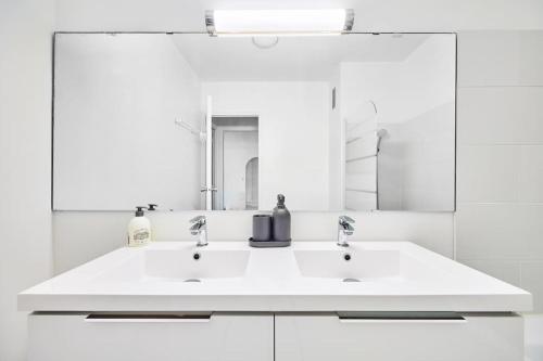 une salle de bain blanche avec un lavabo et un miroir dans l'établissement Charming 2BR Private garden, 5MinToBeach Deauville, à Deauville