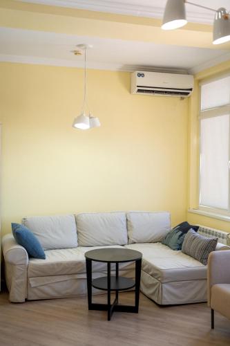 a living room with a white couch and a table at MIRAMAR Apart Hotel & SPA in Aktau