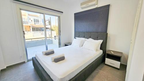 a bedroom with a large bed with a large window at La Magenta Apartments in Pyla